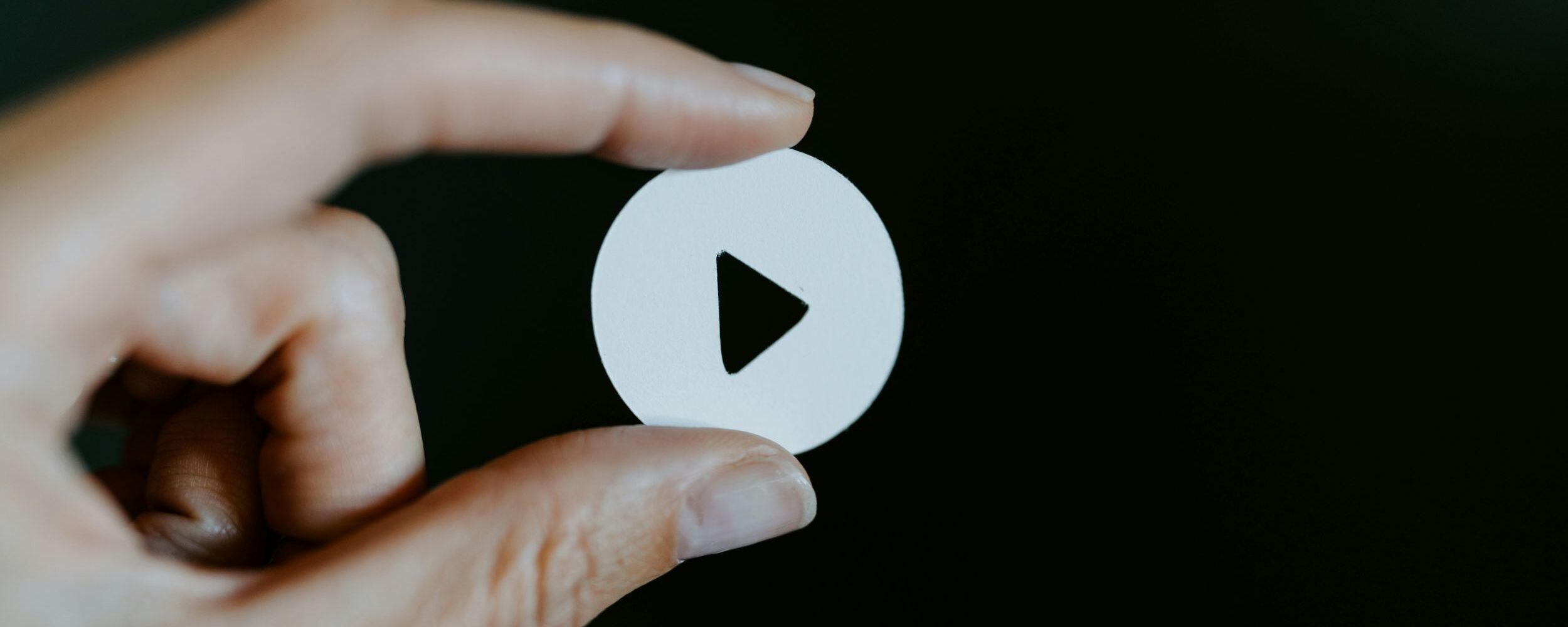 A hand is about to press the play button.